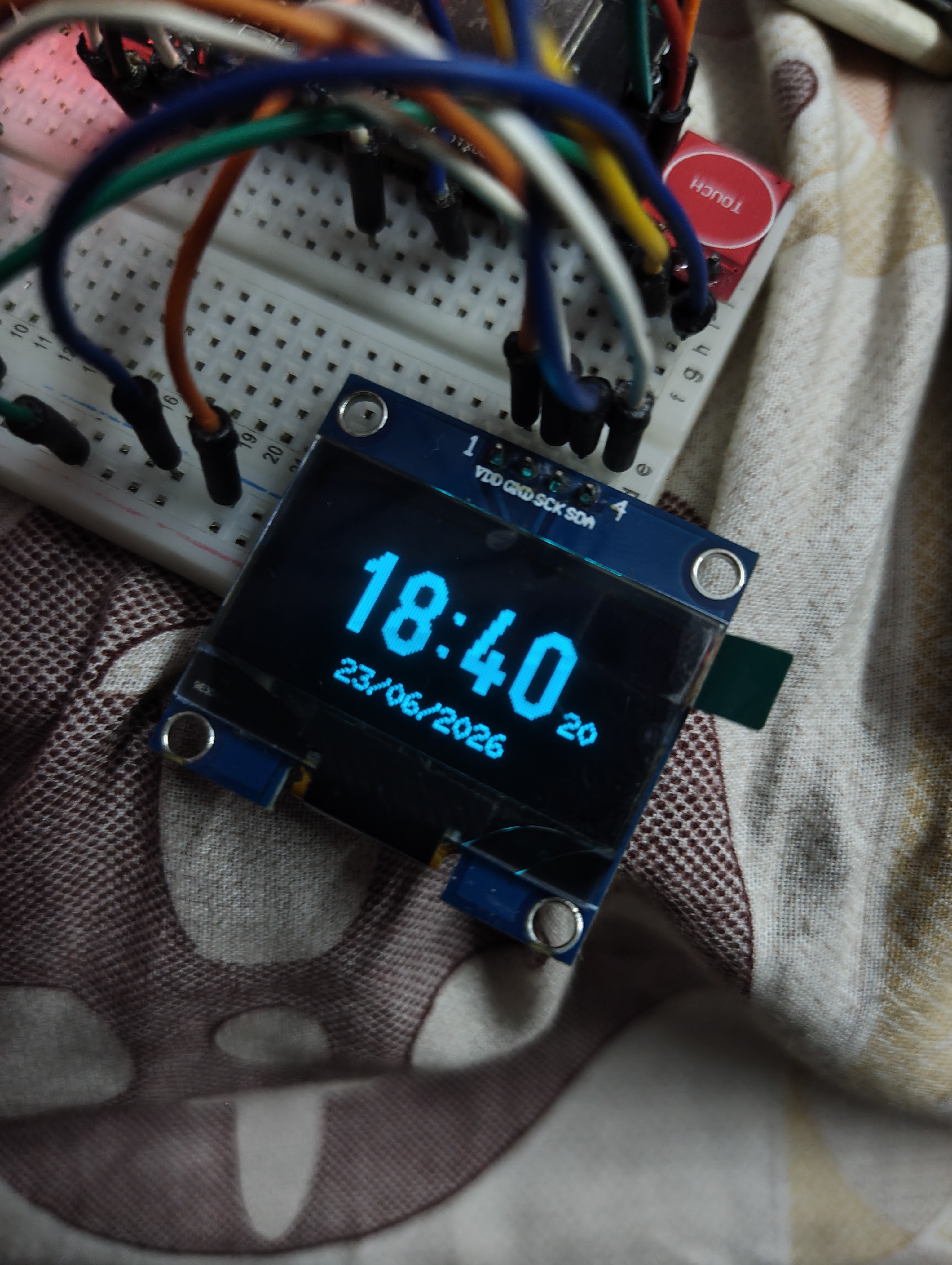 OpenClock-C3 showing the time and date display face on the OLED screen